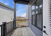 Thumbnail 64 of 69 - A balcony with a black railing and a grey wall.