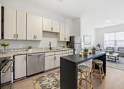 Thumbnail 62 of 69 - A modern kitchen with a black island and wooden stools.