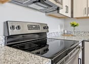 Thumbnail 51 of 69 - A modern kitchen with a stainless steel oven and a granite countertop.