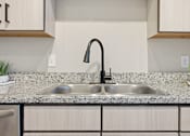Thumbnail 52 of 69 - A modern kitchen with a double sink and a black faucet.