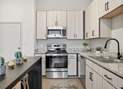 Thumbnail 67 of 69 - A modern kitchen with a stainless steel oven and a black countertop.