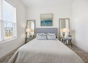Thumbnail 60 of 69 - A bedroom with a large bed, two lamps, and a painting on the wall.