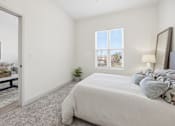 Thumbnail 59 of 69 - A bedroom with a large bed and a window with blinds.