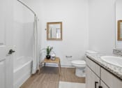 Thumbnail 65 of 69 - A bathroom with a toilet, sink, and mirror.