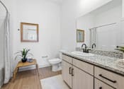 Thumbnail 48 of 69 - A bathroom with a white toilet, sink, and a mirror.