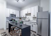 Thumbnail 17 of 69 - A modern kitchen with a black countertop and stools.