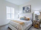 Thumbnail 33 of 69 - A bedroom with a white bed and a painting above it.
