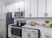 Thumbnail 22 of 69 - A kitchen with a stainless steel refrigerator, oven, and microwave.