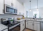 Thumbnail 18 of 69 - A modern kitchen with a black stove and white cabinets.