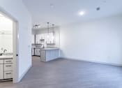 Thumbnail 28 of 69 - A kitchen with a sink and a counter is visible from the living room.