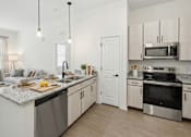 Thumbnail 13 of 69 - A modern kitchen with a granite countertop and stainless steel appliances.