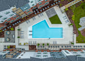 Thumbnail 41 of 69 - A swimming pool is surrounded by a patio and apartment buildings.