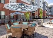 Thumbnail 4 of 69 - A patio with a table and chairs under an umbrella.