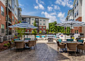 Thumbnail 5 of 69 - A patio with chairs and umbrellas overlooking a pool.
