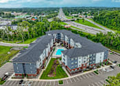 Thumbnail 6 of 69 - A large apartment complex with a swimming pool in the middle.