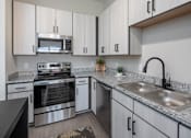 Thumbnail 21 of 69 - A modern kitchen with granite countertops and stainless steel appliances.