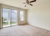 Thumbnail 19 of 25 - A room with a ceiling fan and sliding glass doors.
