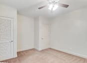Thumbnail 22 of 25 - A room with a ceiling fan and two doors.