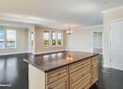 Thumbnail 21 of 25 - A kitchen with a brown countertop and wooden cabinets.