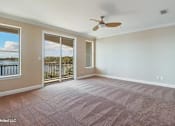 Thumbnail 17 of 25 - A room with a ceiling fan and sliding glass doors.