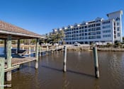 Thumbnail 10 of 25 - A dock with a building in the background.