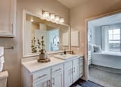Thumbnail 2 of 36 - A bathroom with a white vanity and a large mirror.
