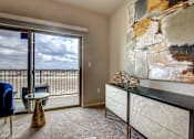 Thumbnail 5 of 36 - A room with a large painting on the wall and a view of the outside through a sliding glass door.