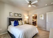 Thumbnail 7 of 36 - A bedroom with a bed, nightstands, and a ceiling fan.