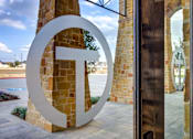 Thumbnail 34 of 36 - A large white letter T is in front of a building.