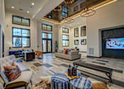 Thumbnail 25 of 36 - A large, well-lit living room with a variety of seating options and a flat-screen TV.