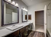 Thumbnail 17 of 36 - A bathroom with a sink, mirrors and lights.