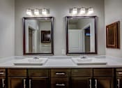 Thumbnail 18 of 36 - A bathroom with two sinks and a large mirror above them.