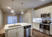 Thumbnail 20 of 36 - A kitchen with white cabinets and stainless steel appliances.