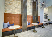 Thumbnail 35 of 36 - A modern living room with a brown tufted couch and a white table.