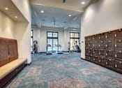 Thumbnail 29 of 36 - A gym with a bench, exercise equipment, and lockers.