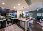 Thumbnail 15 of 30 - A modern kitchen with dark wood cabinets and stainless steel appliances.
