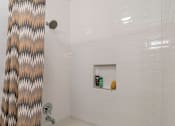 Thumbnail 19 of 30 - A white bathtub with a shower curtain on the left.