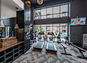 Thumbnail 1 of 30 - A gym with treadmills and a television.