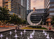 Thumbnail 29 of 30 - A fountain in the foreground with a large building in the background.