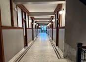 Thumbnail 12 of 14 - A long corridor with a tiled floor and walls.