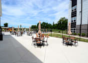 Thumbnail 21 of 27 - Outdoor patio area with tables and chairs  at The Landing Apartments, Indiana