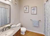 Thumbnail 6 of 27 - Bathroom with a mirror and a toilet and a sink  at The Landing Apartments, Indianapolis