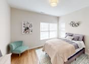 Thumbnail 5 of 27 - Bedroom with a bed and a chair and a window  at The Landing Apartments, Indiana