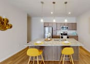 Thumbnail 4 of 27 - Kitchen with a marble counter top and yellow bar stools  at The Landing Apartments, Indiana