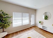 Thumbnail 9 of 27 - Living room with a large window and a door and a mirror  at The Landing Apartments, Indianapolis, IN, 46234