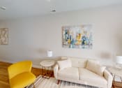 Thumbnail 7 of 27 - Living room with a white couch and a yellow chair  at The Landing Apartments, Indianapolis, IN, 46234