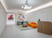 Thumbnail 1 of 25 - A reception area with a wooden reception desk and a mural on the wall.