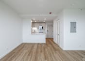 Thumbnail 19 of 25 - A spacious room with wooden flooring and white walls.
