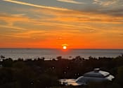 Thumbnail 12 of 25 - A sunset over the ocean with a silhouette of a building in the foreground.at The Nest at Lincoln Park West, Chicago