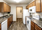 Thumbnail 18 of 46 - A kitchen with wooden cabinets and white appliances. at Standing Bear Lake, Nebraska, 68164